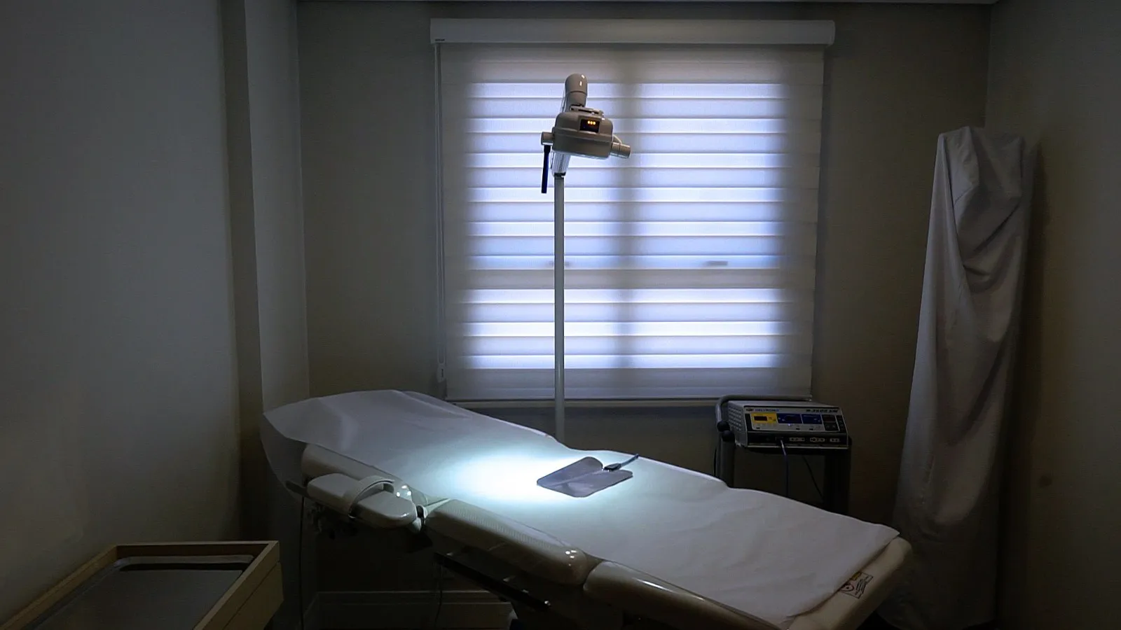 Sala de procedimentos com maca e foco de iluminação